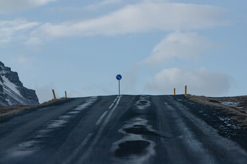 Road sign on a winter road leading to mountains