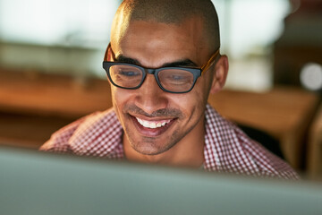 Smile, man and computer in office at night as web designer for research, information and creative project deadline. Happy, male developer with glasses for planning, review or cad systems of overtime