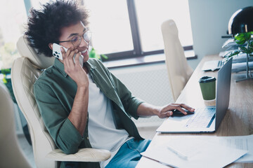 Sticker - Photo of cheerful handsome agent dressed khaki shirt eyewear speaking modern gadget indoors workshop workstation