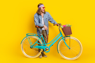 Wall Mural - Full size photo of cool young man bike wear denim shirt isolated on yellow color background