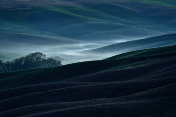 Wall Mural - Field waves with fog, landscape in Tuscany, near the Siana and Pienza. Sunrise morning in Italy. Idyllic view on hilly meadow in Tuscany in beautiful morning light, Italy. Foggy morning in nature.