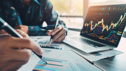 Poster - A financial planner reviewing stock market performance with a client while pointing to a stock market graph on a paper report