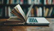 © Anna - An open book and a laptop side by side on a wooden table in a library. The image symbolizes the blend of traditional and modern education methods.