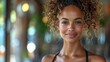 © Viktoriia - Radiant young woman with curly hair smiling