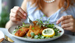 © Oleksiy - Woman eating delicious schnitzel with lemon and microgreens at grey table, closeup