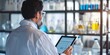 © StudioPix - Scientist in the lab, back view, handling a digital tablet, analyzing experimental results