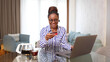 © PeopleVideos - Happy African American woman spending money online
