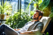 © Garnar - Male employee relaxing peacefully in recliner lounge chair in the break area with green plants in modern office. Mental health, reduction stress, productivity. Concept of sustainable work environment