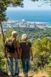 © Ilja - Senior couple on summer vacation, enjoying cityscape and picturesque ocean view from afar
