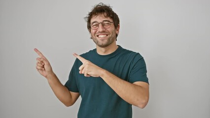 Wall Mural - Cheerful young hispanic guy in glasses pointing to the side with both hands, presenting you a product with a confident smile, standing against isolated white wall.