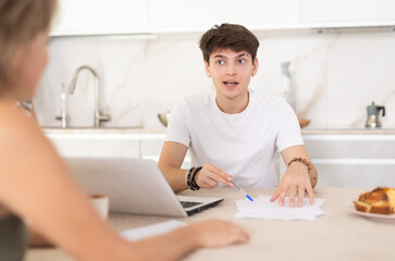 Wall Mural - Guy manager tells woman client about specifics of design of microloan, about benefits and advantages. Seller draws up contract on laptop