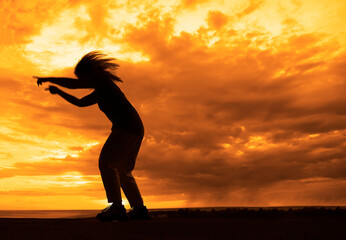 silhouette of  1 one blonde woman dancing with flying long hairs enjoying free time at sunset outdoor. Beauty blond girl portrait at summer. Freedom lifestyle springtime Sun glow on set sky background