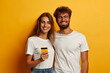 © Dzmitry - Smiling Couple Sharing a Happy Moment While Looking at Phone Against Yellow Background
