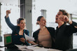 © qunica.com - Joyful business team celebrating their success in an office setting, reflecting teamwork and achievement.