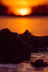 Canvas Print - a close up of water with rocks in the background at sunset