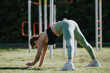 © qunica.com - Athletic woman performing yoga pose during outdoor fitness routine in a sunny park. Healthy lifestyle and exercise.