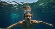 © SevenThreeSky - young guy swimming on underwater background