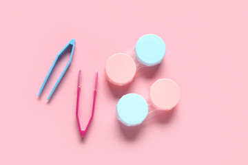 Wall Mural - Containers for contact lenses with tweezers on pink background