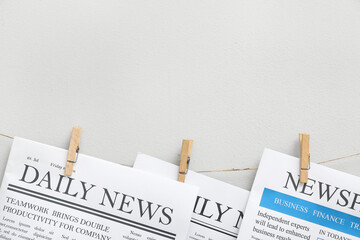 Canvas Print - Newspapers hanging on rope against white background