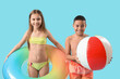 © Pixel-Shot - Cute little children in swimsuit with beach ball and inflatable ring on blue background