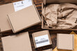 © Pixel-Shot - Cardboard packages with labels on wooden table, closeup