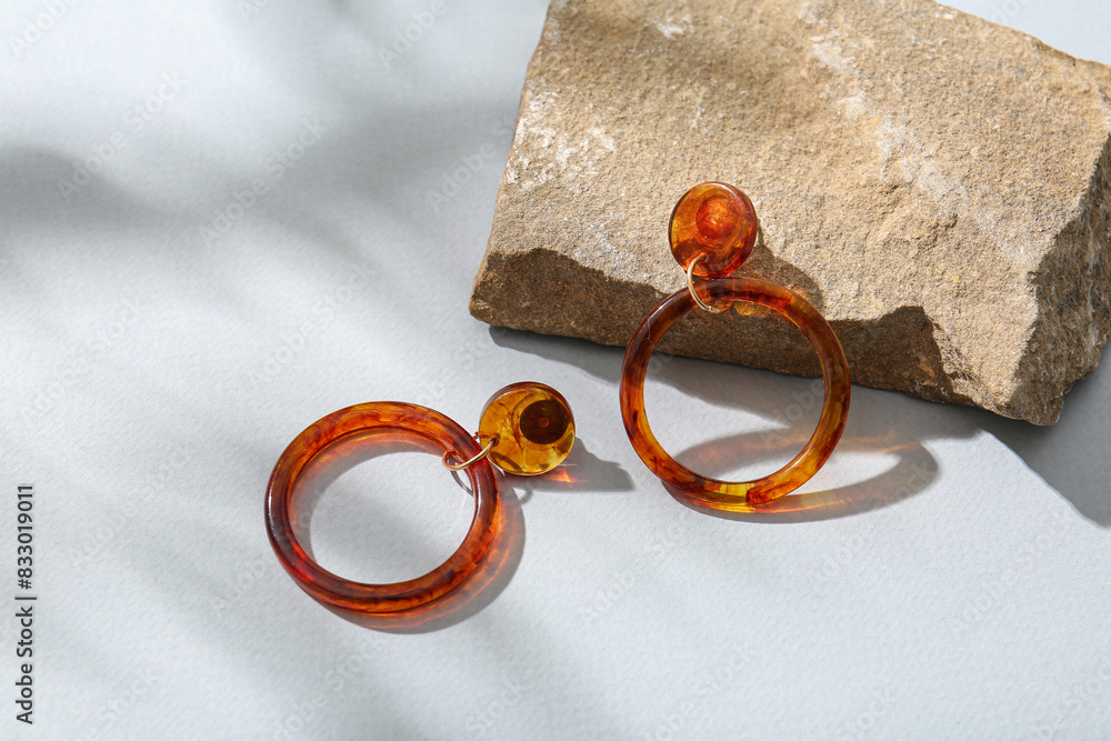 Beautiful earrings with rock on light background