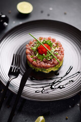 Wall Mural - Tuna and avocado tartare on a dark ceramic plate