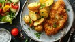 © LukaszDesign - Breaded pork cutlet served with potatoes and side salad