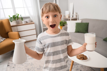 Sticker - Surprised little boy with jug and glass of milk at home