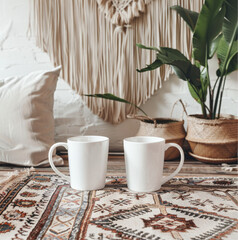  mockup with two 11oz white ceramic mugs The mugs prominently displayed in the foreground with clean white surfaces and no designs on the front. Surround the scene with inspired decor 