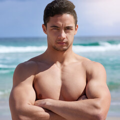 Canvas Print - Arms crossed, muscles and portrait of man on beach in summer for holiday, travel or vacation. Sea, serious and sky with body of shirtless person on coast by ocean for exercise, fitness or workout