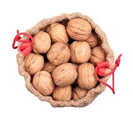 Wall Mural - Walnuts in their shells, in an opened gunny sack. Unshelled dried seeds of common walnut tree Juglans regia. Whole nuts with shells, used as snack, for baking and as decoration, in an opened jute bag.