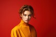 © MediaRaw - A woman in a yellow shirt is standing in front of a red background