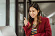 © M+Isolation+Photo - A young woman and other Asian individuals in formal suits are seen working at desks with laptops, portraying a successful and happy demeanor.