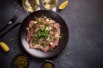 Wall Mural - tuna carpaccio - slices of fresh raw tuna fillet on black ceramic plate