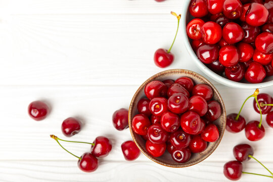 Cherries. Fresh ripe cherries with leaves on a textured wooden background. Fresh sweet organic cherry pile. Berries and fruits. Vegan. Healthy eating. Place for text. Copy space
