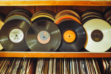 A collection of vintage vinyl records arranged on a shelf, capturing the nostalgia and retro vibe of analog music.