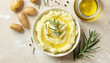 © Cadengo - Bowl of tasty mashed potato with rosemary and olive oil on beige wooden table
