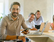 © OceanProd - Startup bearded man boss with team member smiling at camera in office