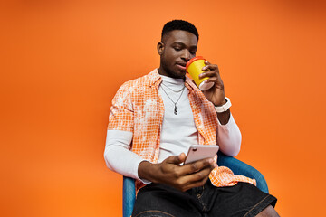 Wall Mural - Handsome African American man sitting, holding coffee cup.