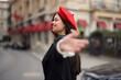 © SHOTPRIME STUDIO - Fashion woman smile with teeth standing on the street in front of the city tourist follow me stylish clothes with red lips and red beret, travel, cinematic color, retro vintage style, urban fashion.
