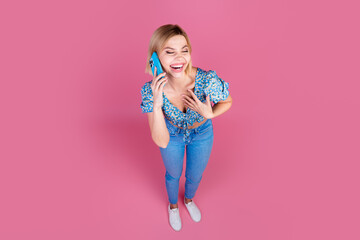 Canvas Print - Full size high angle view photo of pretty young girl speak phone laugh wear top isolated on pink color background