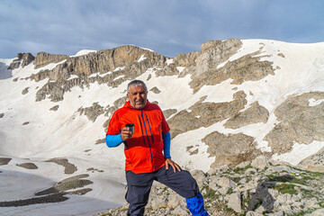 Wall Mural - Mountaineer is posing with a cup of coffee in front of the summit, Antalya