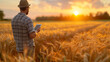 © aekkorn - Man Standing in Wheat Field Holding Tablet.