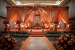 © Design Depot - A lavish wedding stage setup with orange curtains and an array of flowers, ideal for matrimonial ceremonies
