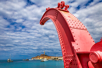 Wall Mural - Red old historic crane in the port unloading ships panorama view of Rovinj