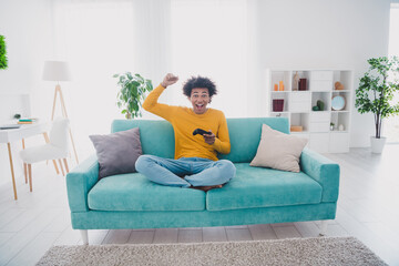 Poster - Full length portrait of nice young man raise fist play game wear pullover white interior flat indoors