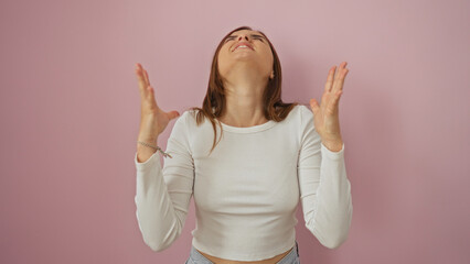 Poster - Young attractive woman with blonde hair poses over an isolated pink background, expressing frustration with raised hands and a tilted head.