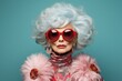 © juliars - Fashion-forward elderly woman with white hair and large red sunglasses on a teal background