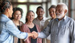 © Катерина Євтехова - a detailed image of a senior professional shaking hands with a younger colleague, symbolizing mentorship and career achievement, Multiracial Group, multi generational, Senior peopl